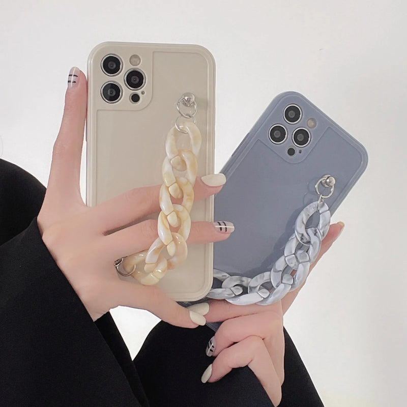 Silicone marble bracelet phone case with integrated lanyard hole for iPhone models 7 through 15 Pro Max, designed with shock-absorbing TPU soft shell and available in antique white, grey blue, and transparent coffee colour options.