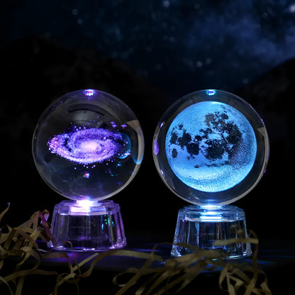 Transparent crystal ball ornament with inner carving of clouds, shown on a wooden table.