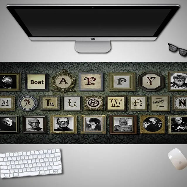 Oversized black Halloween-themed mouse pad with graphic design on a wooden desk, showing non-slip rubber base.