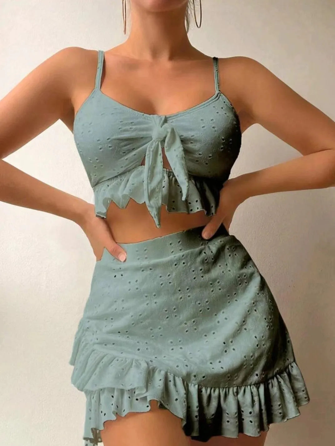 Women's white split hip skirt three-piece bikini swimsuit set on a mannequin.