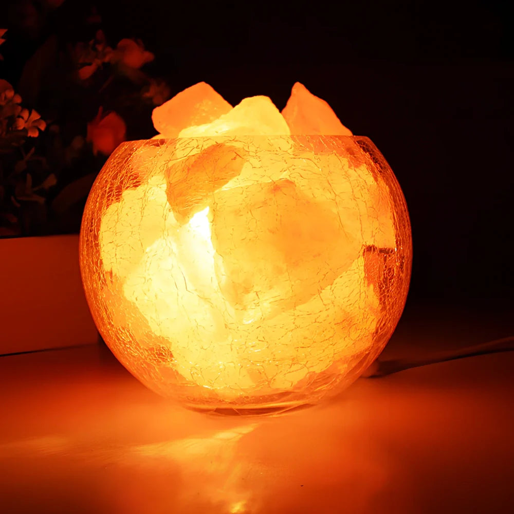 Crystal salt bedside lamp with glass shade and USB cable on wooden table