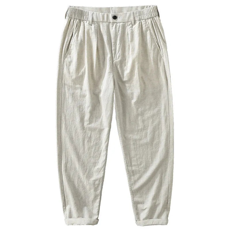 Man wearing loose beige straight-leg cotton linen trousers in a casual setting