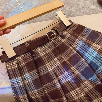 Girls' plaid pleated A-line skirt in cotton blend fabric on a hanger.
