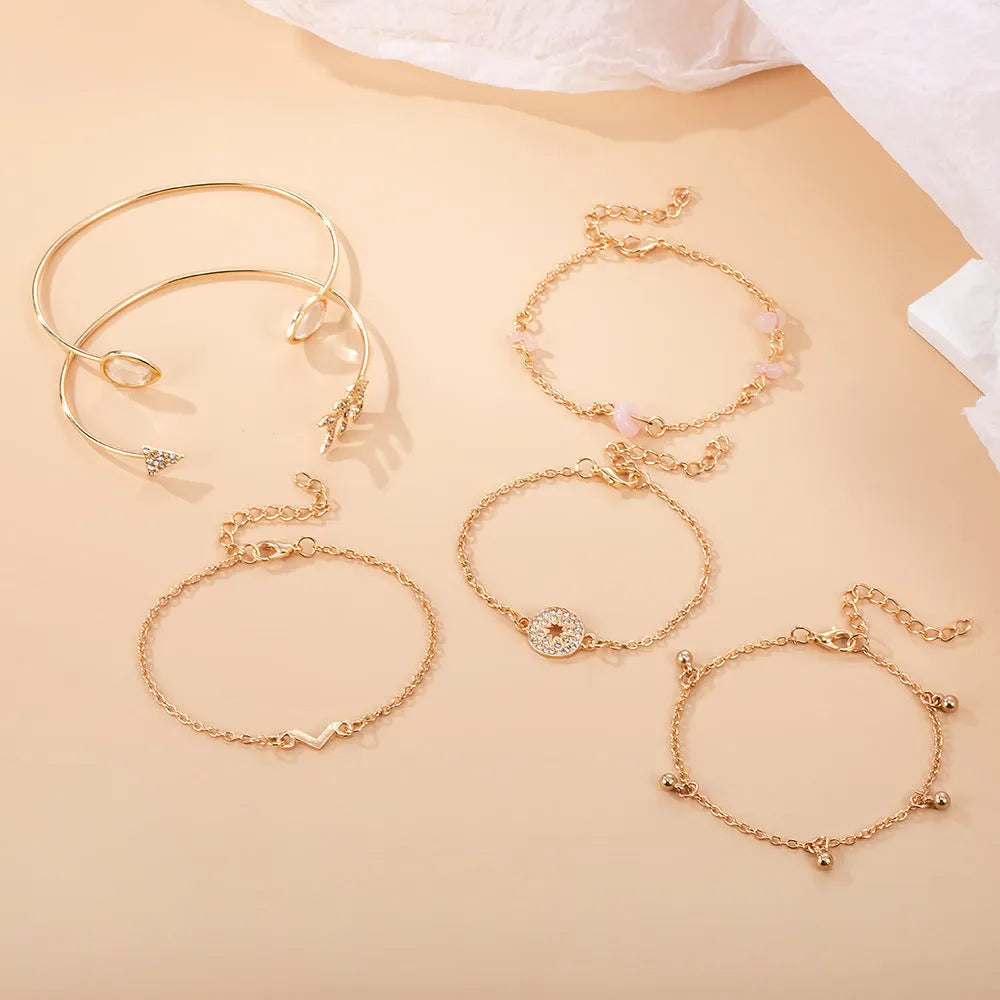 Set of six gold-colour zinc alloy bracelets with water drop, arrow, and V-shaped charms.