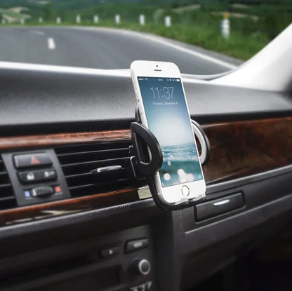 Black plastic mobile phone holder attached to a car air conditioning vent.