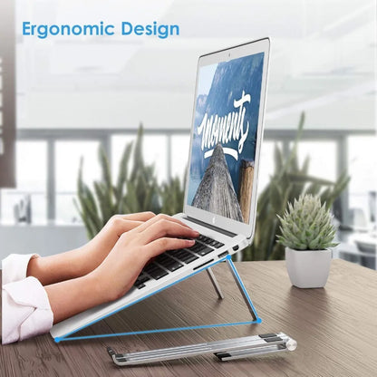 Black and silver aluminum laptop stand measuring 26cm wide on a wooden desk.