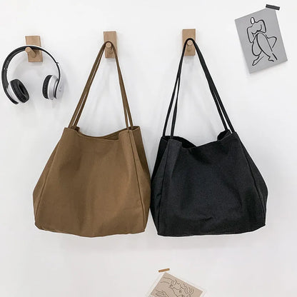Solid colour women's canvas handbag with double shoulder straps showing internal mobile phone compartment