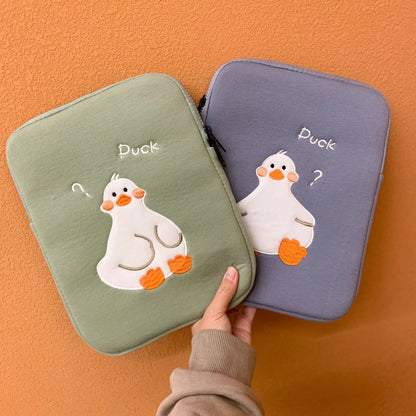 Blue tablet case with embroidered cartoon duck design showing zipper closure and cotton fabric texture