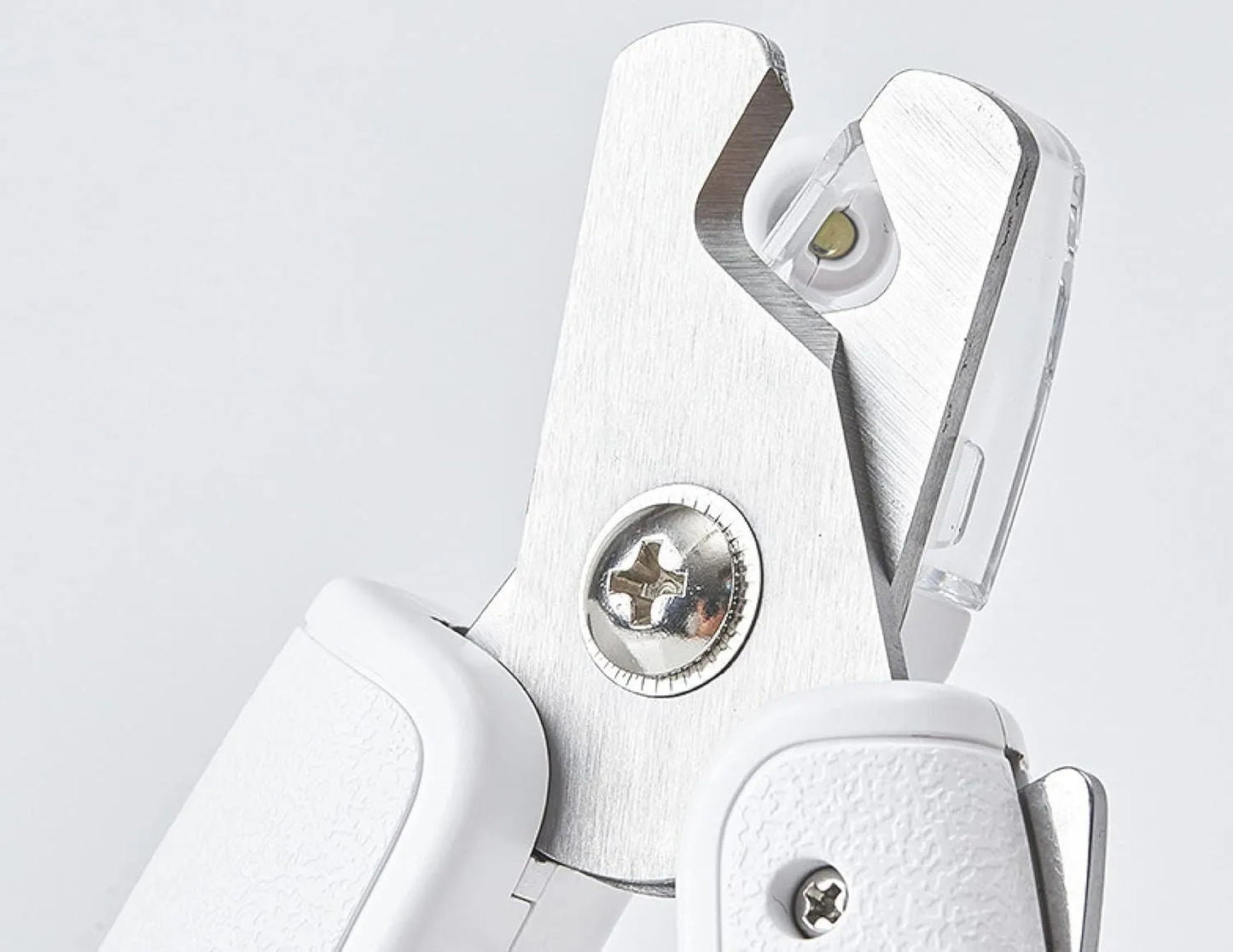 White pet nail clippers with LED light, anti-splash guard, and built-in nail file on a flat surface.