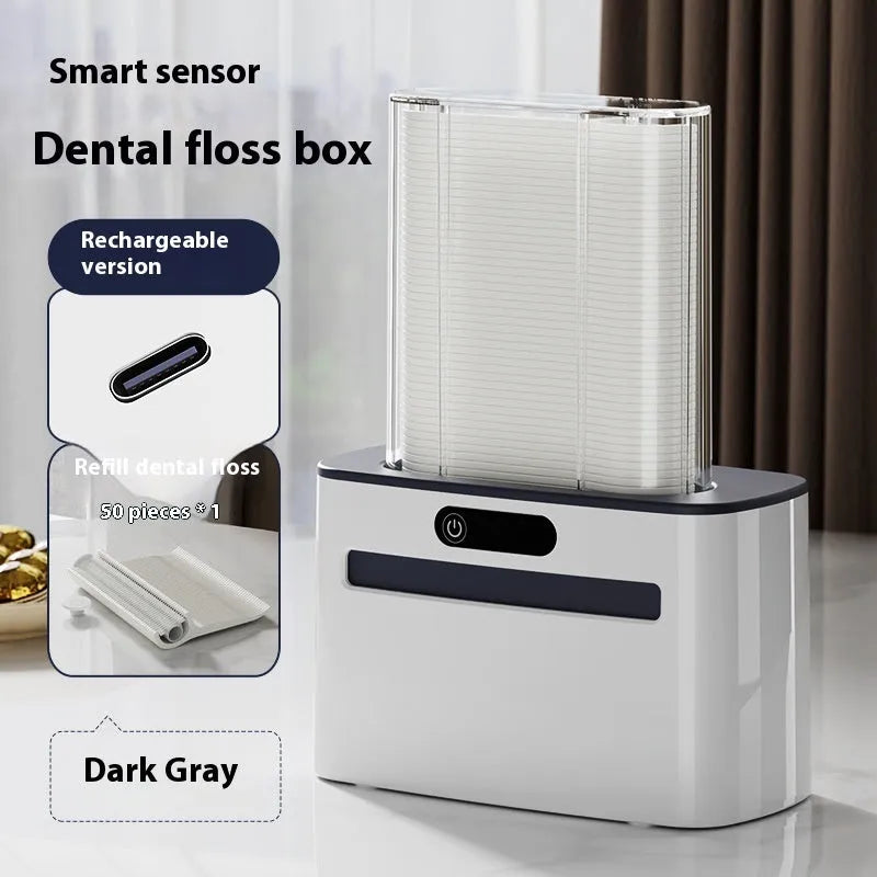Dark grey automatic electric dental floss box with pop-up mechanism on a bathroom counter.