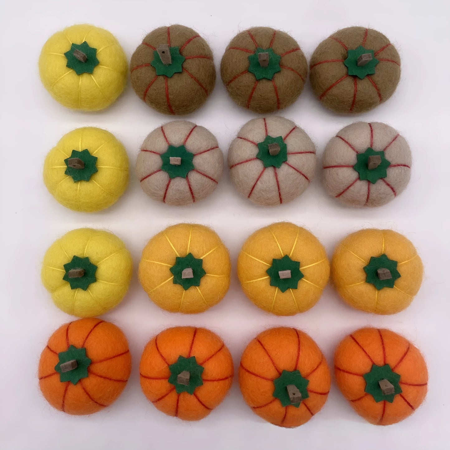 Wool felt pumpkin ornaments in various colours for doll decoration and craft projects.