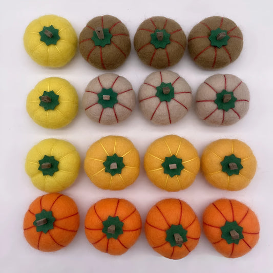 Wool felt pumpkin ornaments in various colours for doll decoration and craft projects.