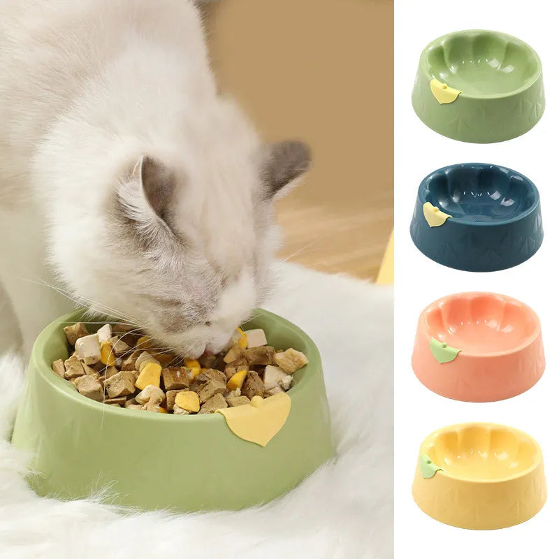 Green plastic double pet bowl with two compartments for food and water on a flat surface.