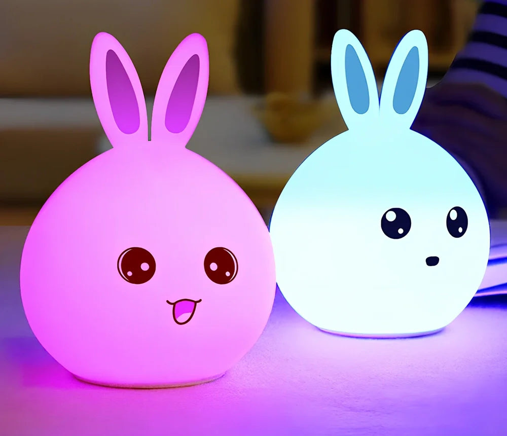 White silicone rabbit night light with USB charging cable showing touch sensor area and colourful LED illumination