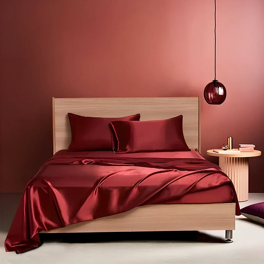 Navy blue floral pattern silk bedding set with quilt cover, fitted sheet, and two pillowcases on bed