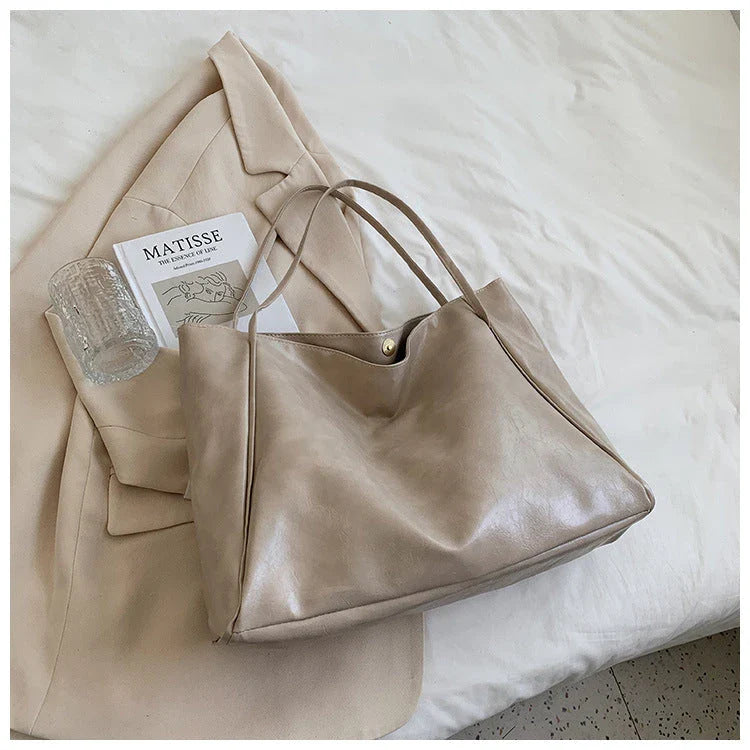 Stylish leather shoulder bag in various colors, including wine red, blue, black, brown, and beige. Showcases a versatile and spacious design for everyday use.