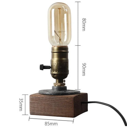 Compact wooden and iron water pipe table lamp on a table.