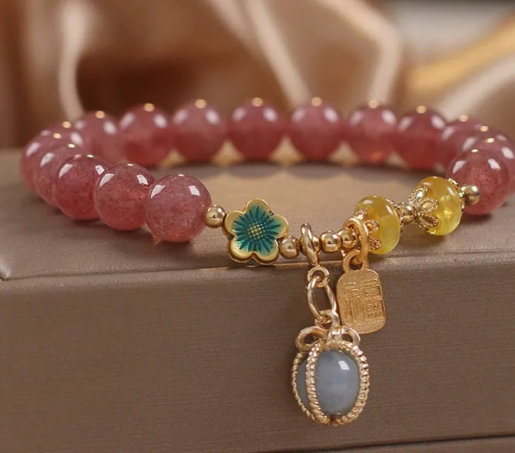 Red women's bracelet with strawberry quartz beads and rhinestones on an alloy chain.