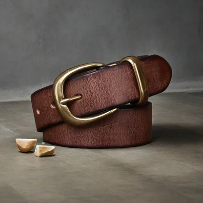 Men's black genuine cattlehide leather belt with a copper pin buckle on a jeans background.