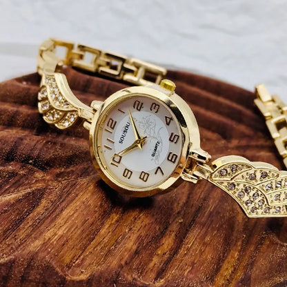 Round stainless steel women's watch on wrist showing gold surface colour and vachette clasp buckle.