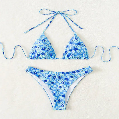 Blue printed women's bikini set with lace-up front top and high-leg split shorts on a mannequin.