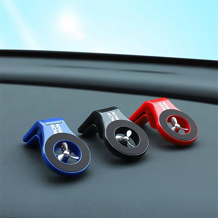 Black magnetic car phone holder attached to air vent with smartphone mounted and fragrance slices visible