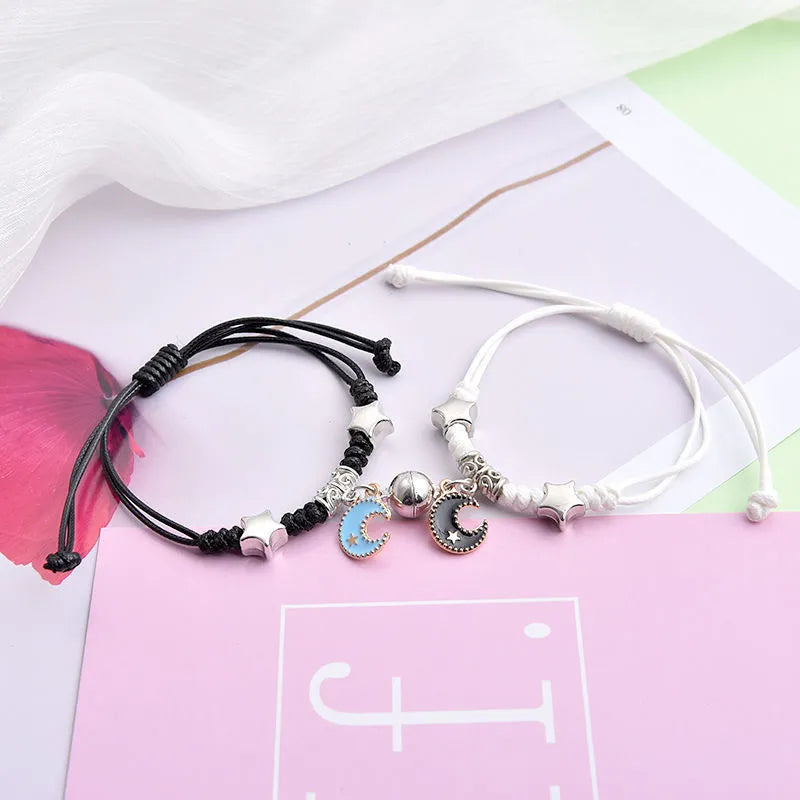 Magnetic suction couple bracelet pair in alloy with an electroplated finish, showing example designs like a crown and love lock.