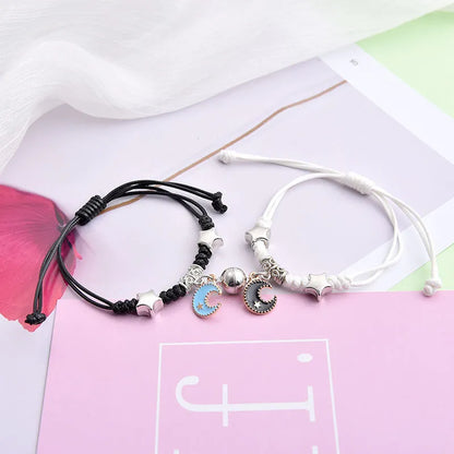 Magnetic suction couple bracelet pair in alloy with an electroplated finish, showing example designs like a crown and love lock.