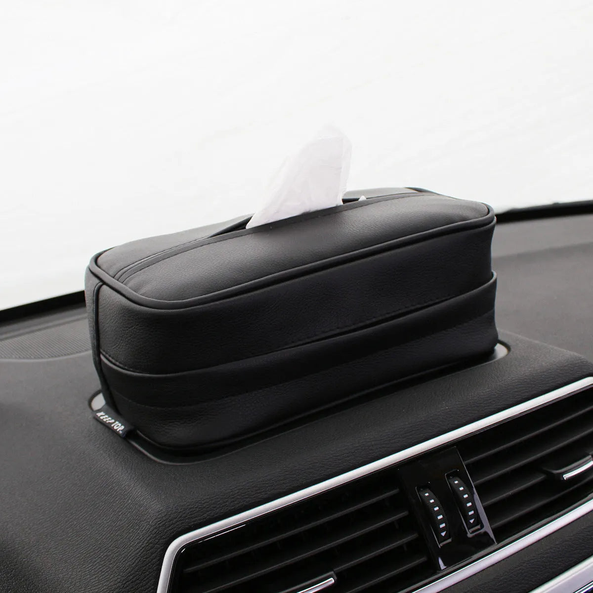 Black leather hanging storage box with PU coating, dimensions 23x13x9cm, shown behind a car headrest