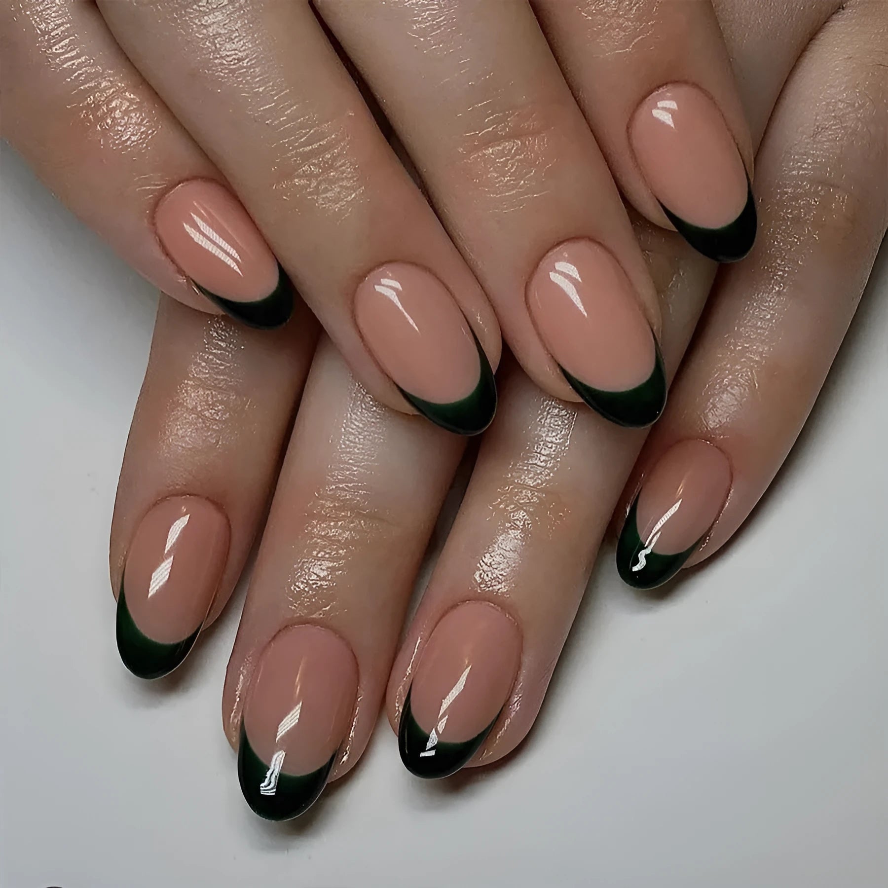 Set of 24 black French style false nails in a short almond shape laid out on a white surface.