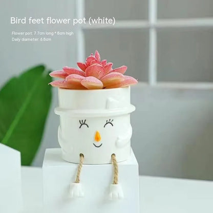 Ceramic hanging foot flowerpot for succulent plants with cartoon styling on desktop