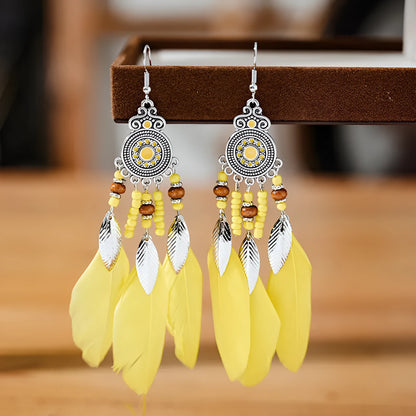 Bohemian feather leaf pattern alloy earrings in round drop shape on a colour selection background.