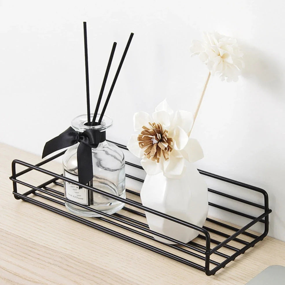 Black wrought iron bathroom shelf, 60cm long with drainage holes, holding shampoo bottles over tub edge