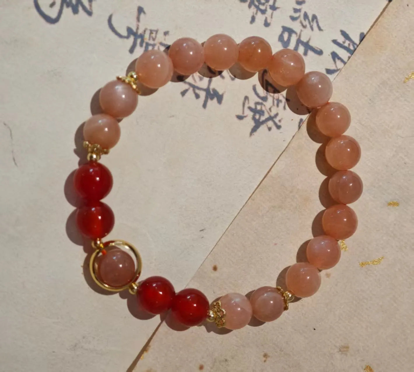 Women's handmade red agate and sunstone bracelet with ethnic charms