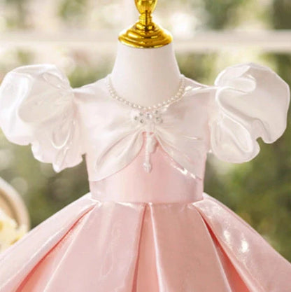 Girls pink puff sleeve princess dress with colour-coordinated design on hanger
