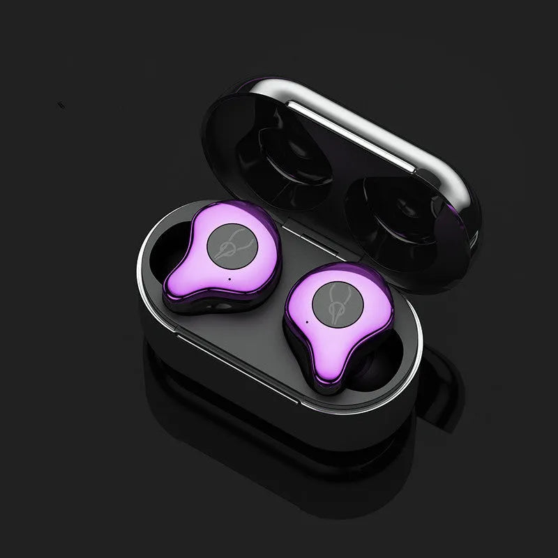 Coffee-coloured true wireless Bluetooth earbuds sitting in an open charging case on a wooden table.