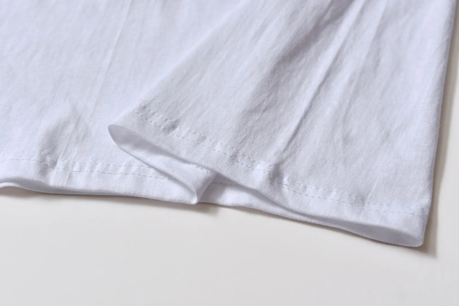 White cotton pullover overalls with a pattern, short sleeves, and a round neck on a teenager.