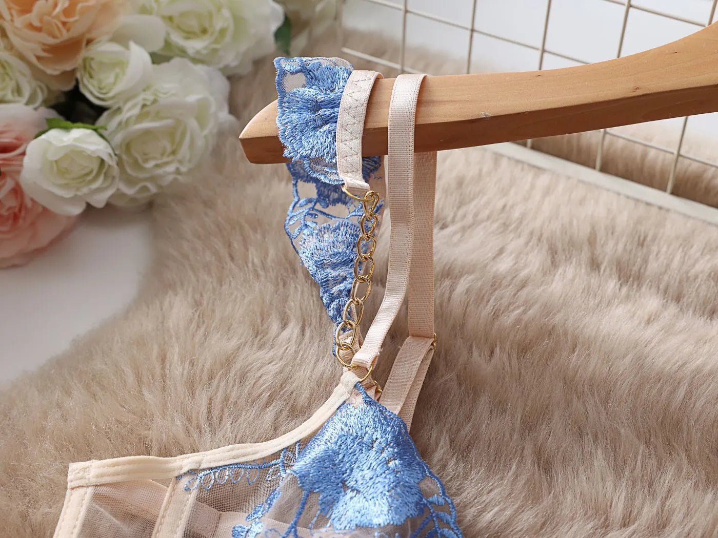 Light blue embroidered lace bra and knicker set with transparent mesh panels on a mannequin.