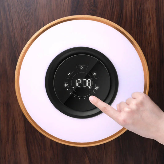 Round Bluetooth speaker with LED tree lighting and wireless charging surface in maple brown finish