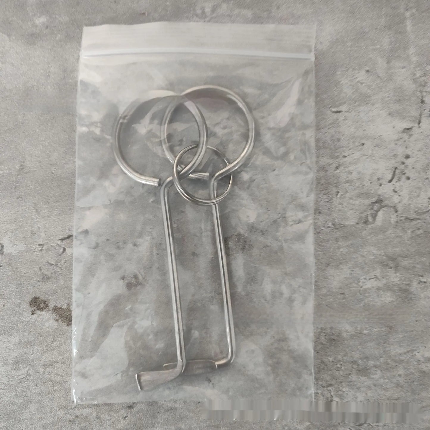 Two silver alloy wrench tools from a portable universal family set on a plain background.