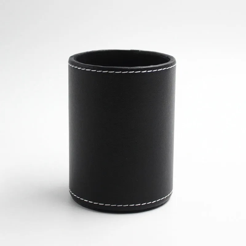 Round black leather pen container measuring 8.0cm diameter by 10.8cm height on wooden desk
