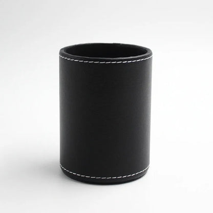 Round black leather pen container measuring 8.0cm diameter by 10.8cm height on wooden desk