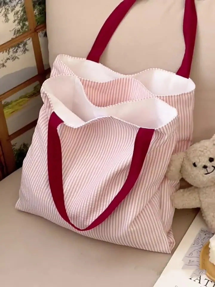 Light pink striped cotton canvas multi-layer tote bag with a wide shoulder strap.