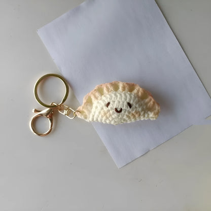 Handmade crochet dumpling pendant with keychain showing plush texture and hand-stitched decorative eyes