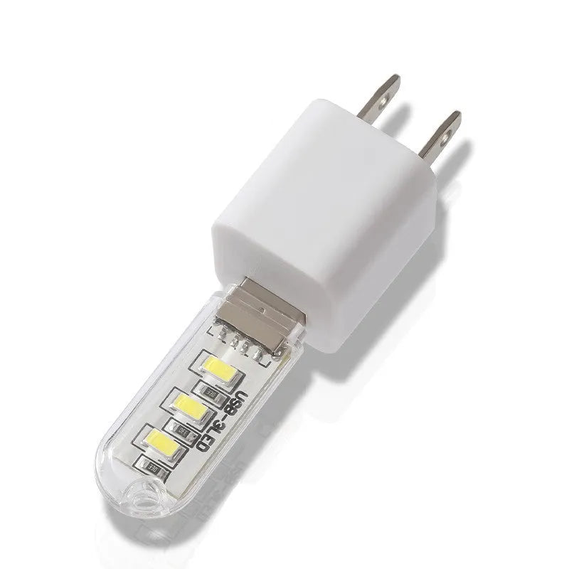 Small white USB LED baby night light showing warm and white light modes on a table.