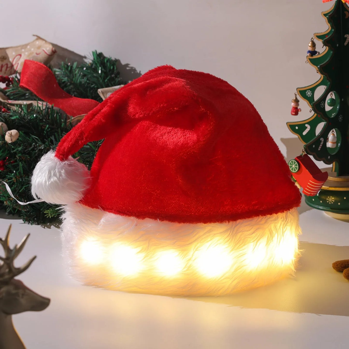 Red and white plush Santa hat with LED lights around brim in Christmas setting