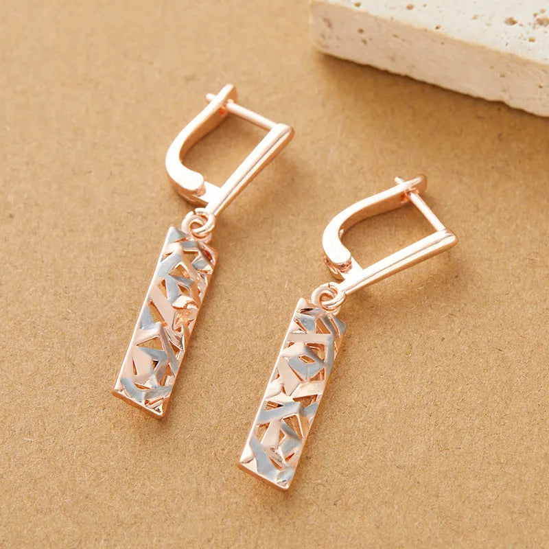 Rectangular two-tone hollow stud earrings with a geometric design and electroplated finish.