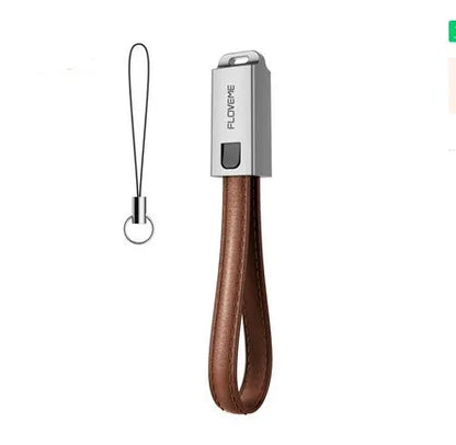 Short black leather iPhone charging cable with metal connector next to a power bank