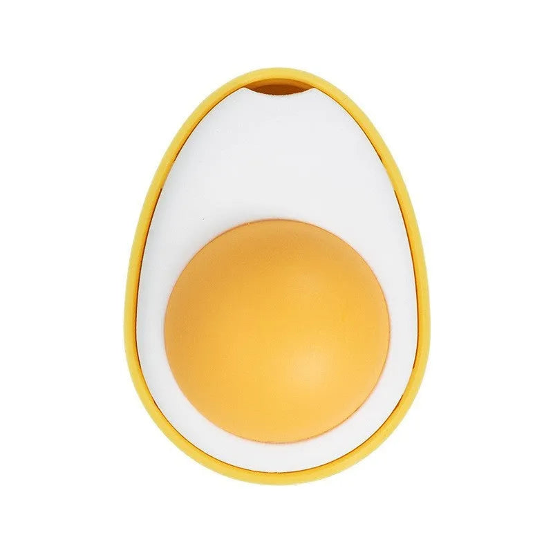 Plush Fried Egg shaped cat toy stuck to a window, being batted by a cat's paw.