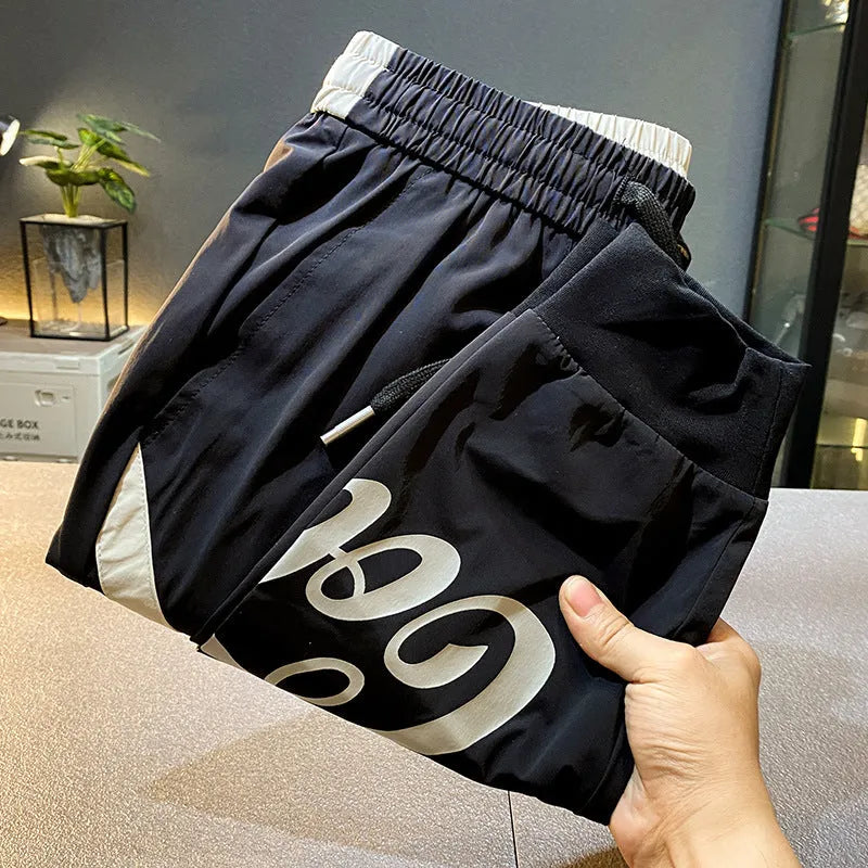 Black men's casual cotton trousers with a cropped, ankle-banded leg design on a neutral background.